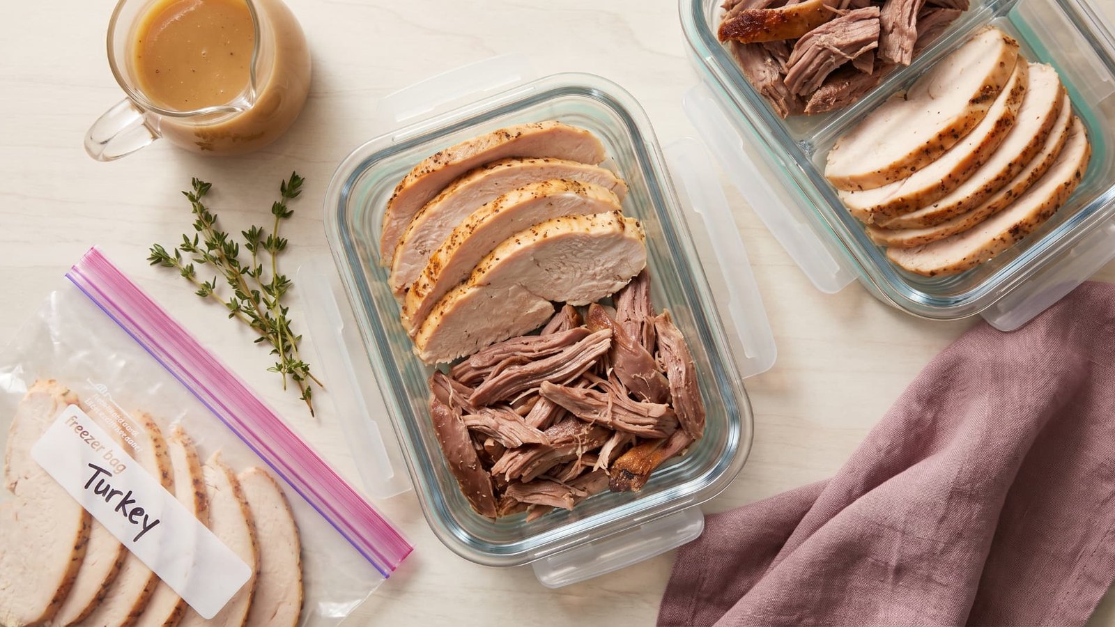 Leftover turkey packed into glass containers and a labeled freezer bag for storage